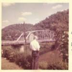 Photo courtesy of Mark Sefton. He writes. My Grandfather N.L. Sefton standing in the back yard overlooking the old bridge and YMCA. Peach Creek bridge and N. L. Sefton, Logan County, WV
