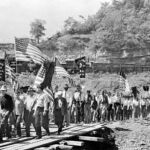 1921 Logan, WV union members marching onto the Island during the Battle of Blair Mountain. Courtesy of UMWA. Ref. Imaage 19210134. 1921 Logan, WV union members marching