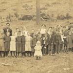 Picture of Principal Garnett O. Nelson with teachers and students courtesy of Brenna Mitchell.
From his obit. Garnett was born at Simoda. His parents were Joseph W. Nelson and Martha A. Hedrick. He was the principal of a grade school and listed his employer as the Logan County Board of Education when he registered for the draft. Garnett registered on 24 May 1917 in Logan County, WV.
That death leaves a shining mark was said long ago and has been demonstrated over and over. But perhaps never more strikingly so than in the subject of this sketch. Garnett Otis Nelson was born June 21, 1890. Entrained for Camp Lee May 25, 1918, and died November 15, 1918. In Camp Lee he was promoted to office of Corporal and in France he became a Sergeant.
In 1907 he completed the free school course, then taught in his home county of Pendleton four years, completed the state normal course at Shepherd College in the class of 1914. Later he attended the West Virginia University and taught in Logan County four years; one year as principal of the Henlawson school and three years as principal of Logan city school. Garnett Otis Nelson Postcard photo with teachers and students