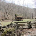 Sign reads: "Early Pioneer Homestead (1770-1863). This log cabin is authentic example of the type of homes built by the pioneer families in Southern West Virginia between the Revolution and the Civil War. West Virginia was granted statehood on June 20, 1863." Chief Logan State Park Pioneer Cabin