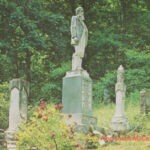 Hatfield Family Graveyard postcard courtesy of Christine Gray. Photo by Charles L. Elkins. “In 1880, a Hatfield had a difference of opinion with a McCoy over a wild pig and $1.75. This developed into a feud which became a southern Appalachian folklore classic. Feuding became a family tradition as portrayed in a verse from the ballad <em>‘Jim Hatfield ‘s Son’: <br />
To never fail the Hatfield clan, <br />
For he was born to fight; <br />
To never be afraid to die, <br />
And shoot McCoys on sight.”</em> Hatfield Family Graveyard